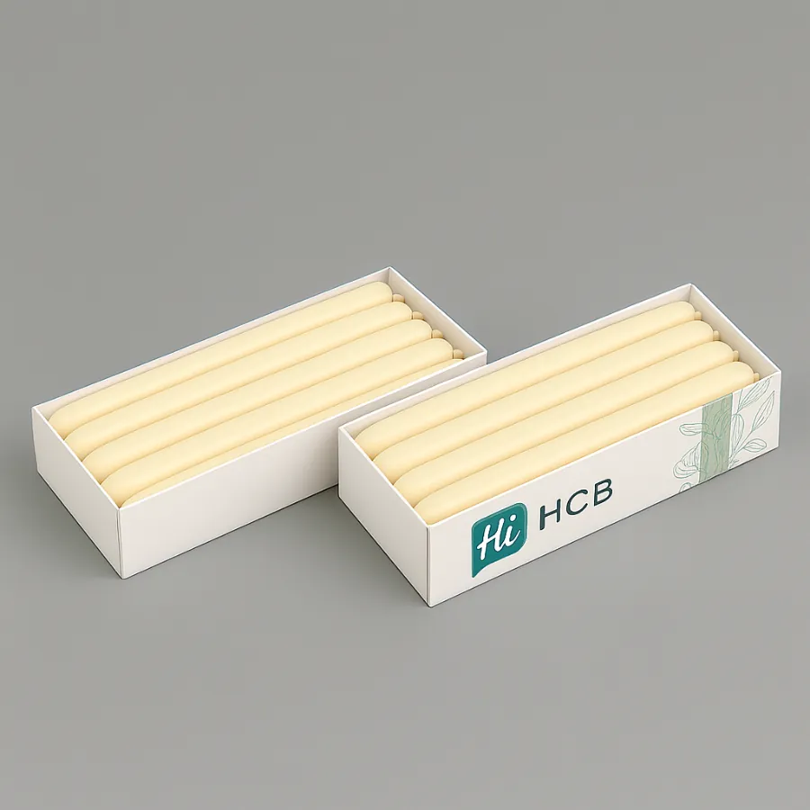 Two rectangular white boxes displaying rows of six long- cream-coloured taper candles- class=